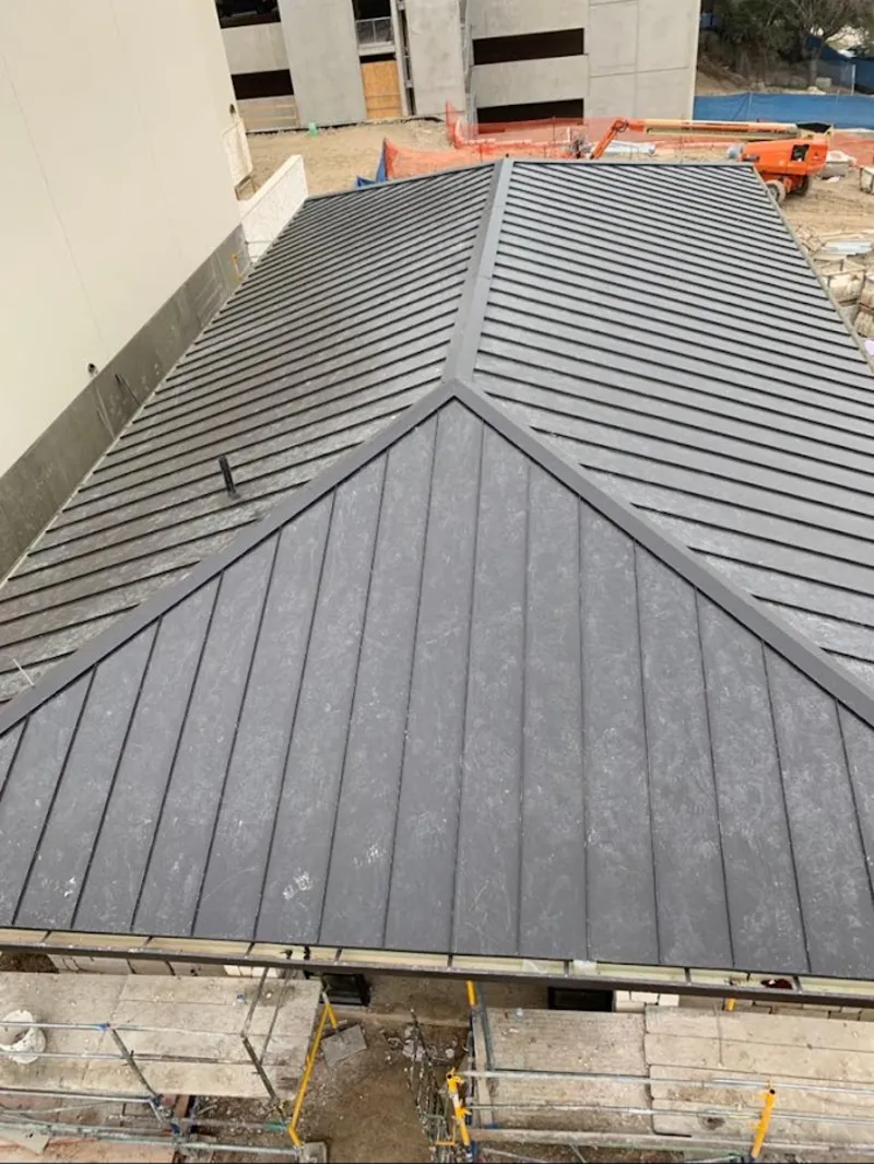 Commercial metal roof construction with crane equipment in Scriba